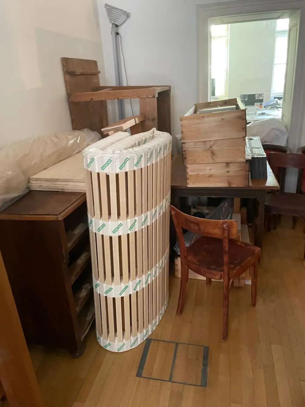 Matratze, Lattenrost und Holzmöbel in einem Zimmer, bereit zur Abholung